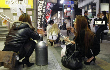 2011年4月7日晚，日本東北部海域發(fā)生里氏7.4級地震，民眾采取各種方式避災。圖為仙臺民眾在街頭蹲下躲避。